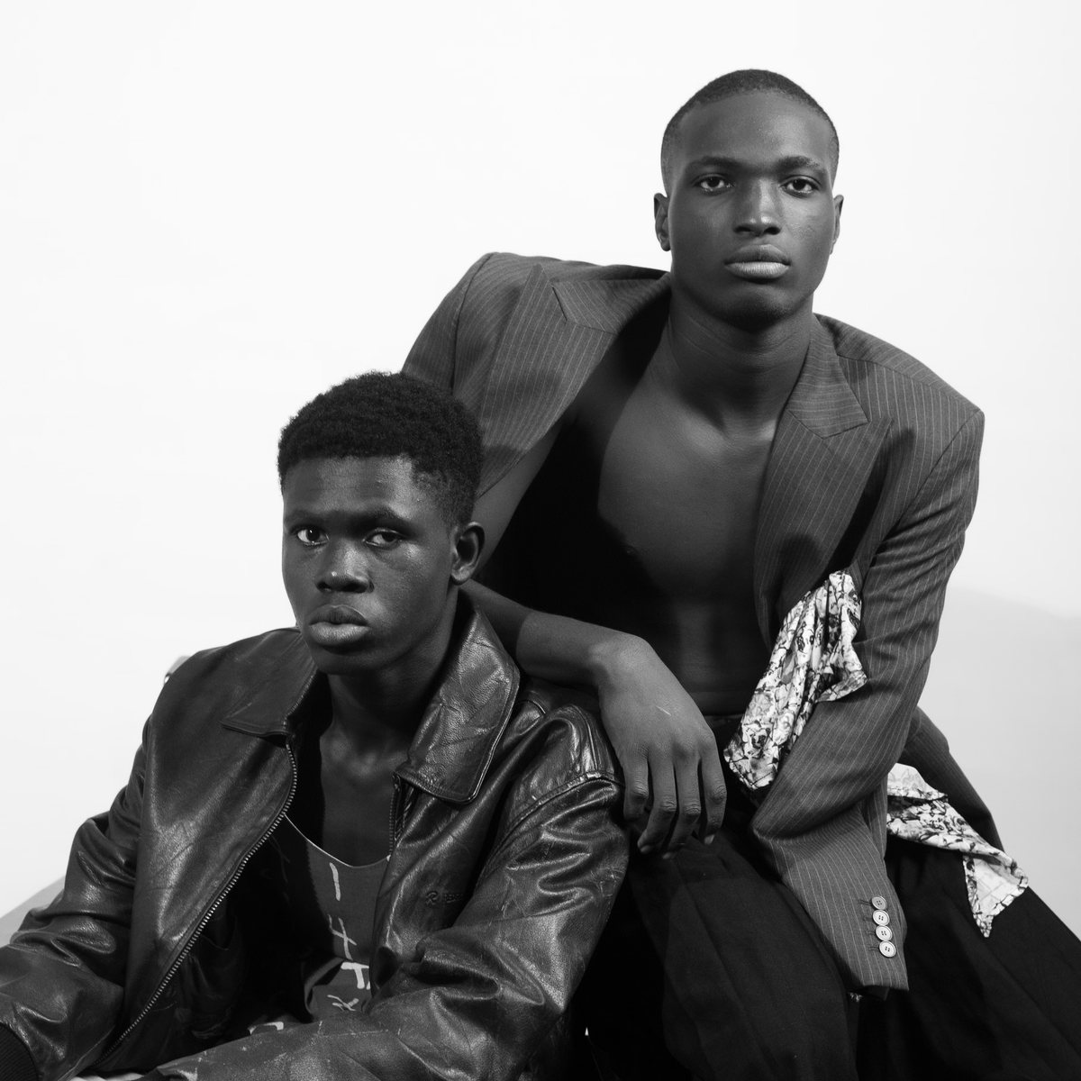 Two models in tailored jackets, black and white studio portrait