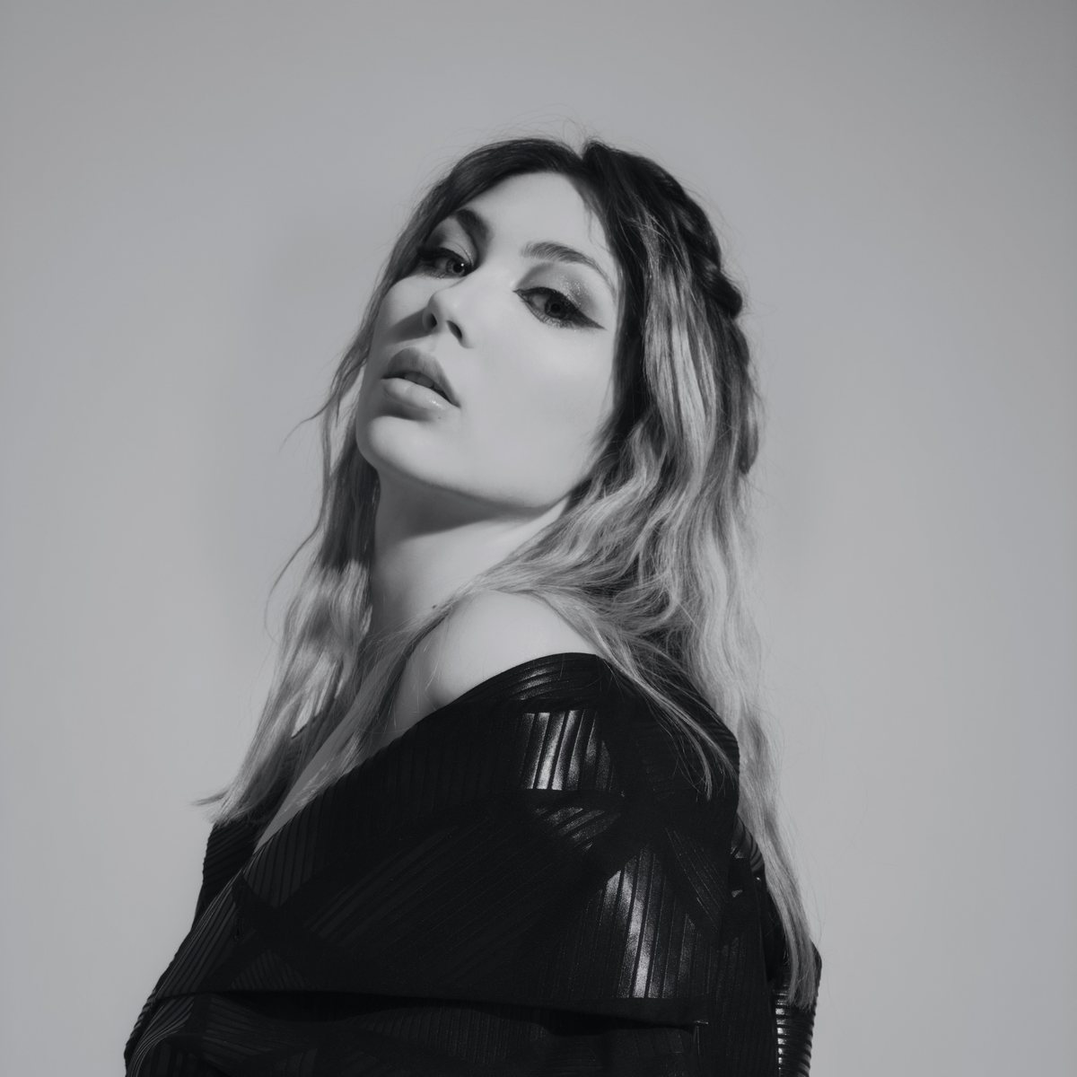 Model in a structured black jacket looking over her shoulder