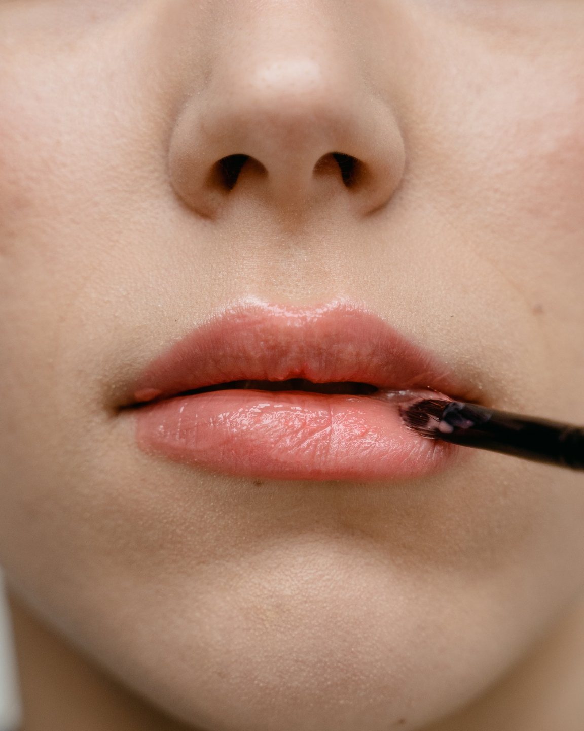 Gloss brushed onto lips, close up