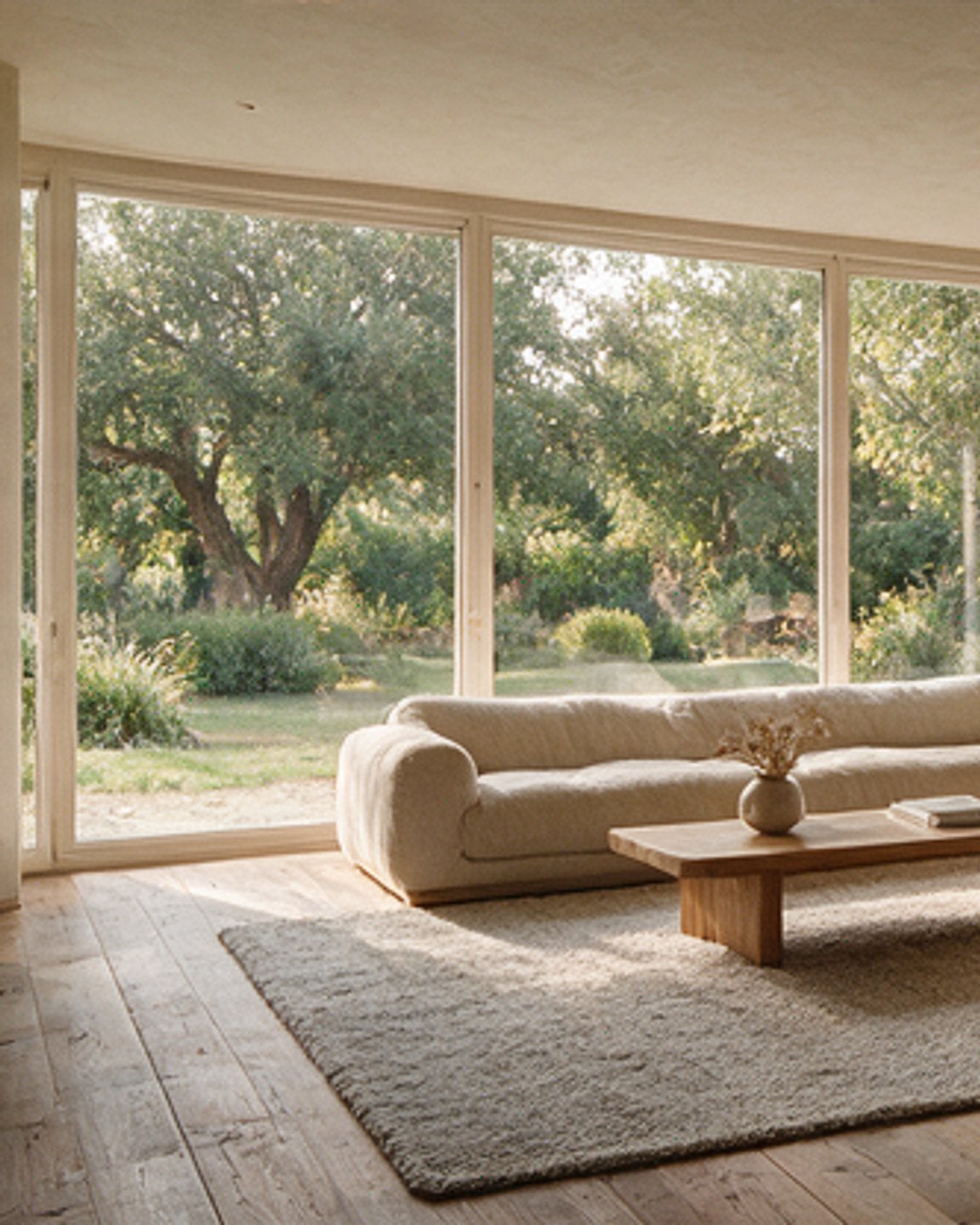 Garden room at Casa Alzina with a boucle sofa facing floor-to-ceiling glazing