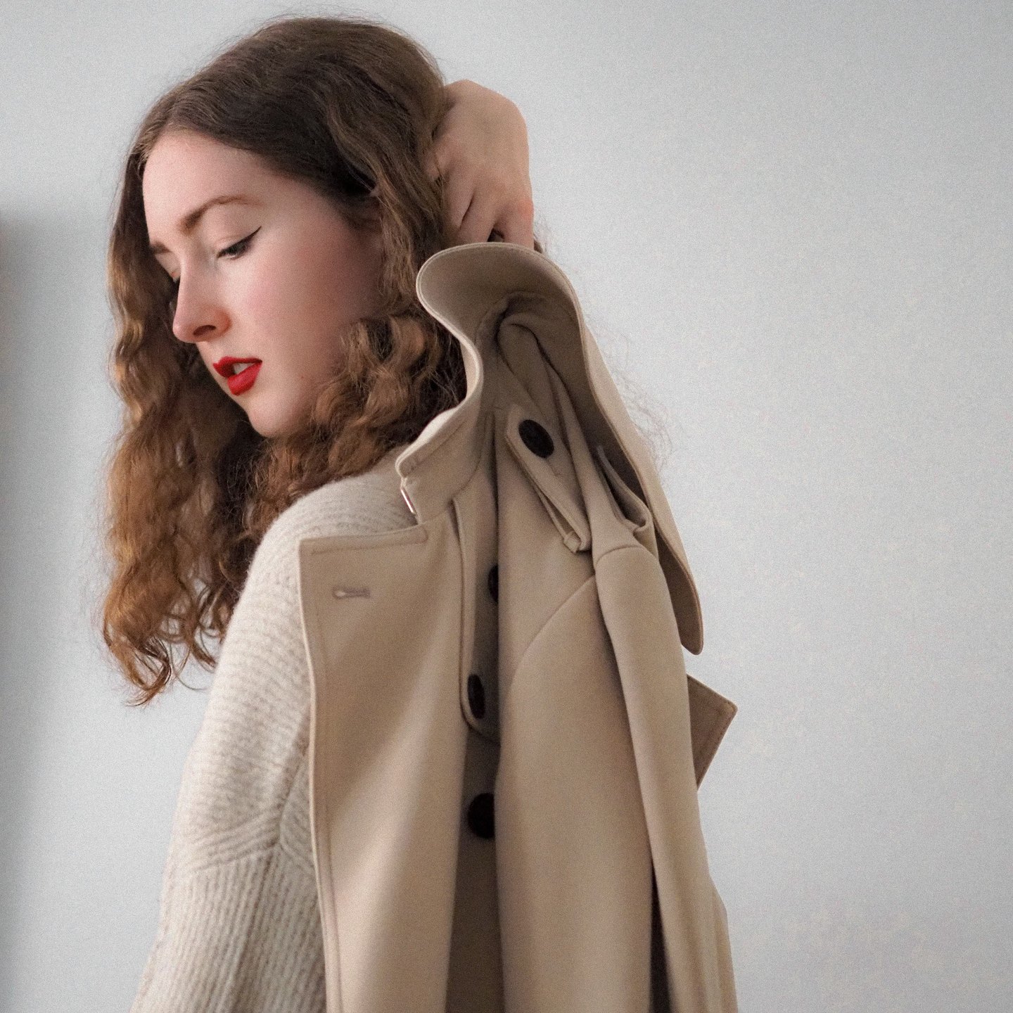 Camel wool coat draped over the shoulder