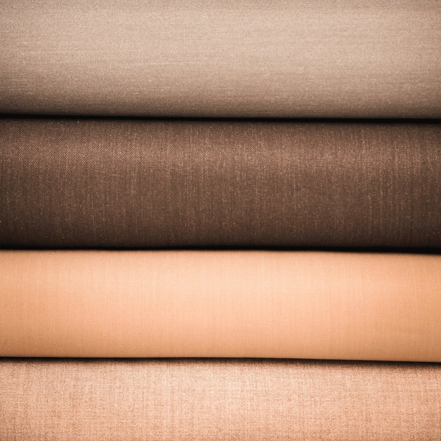 Folded bolts of wool cloth in earthy tones