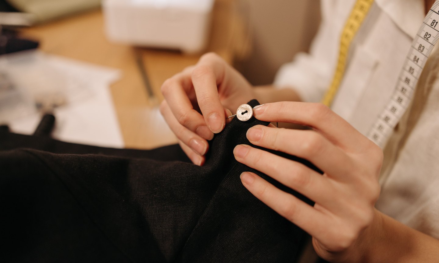 Hand-finishing a button in the atelier