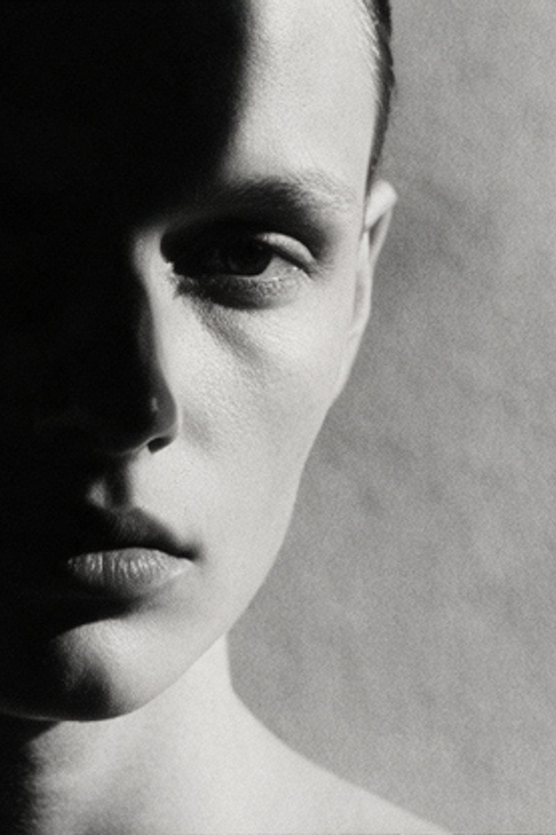 Half-shadowed face in high-contrast monochrome