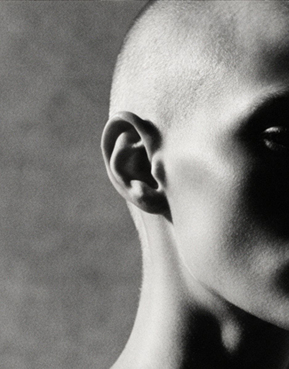 Close crop of a shaved head in raking monochrome light