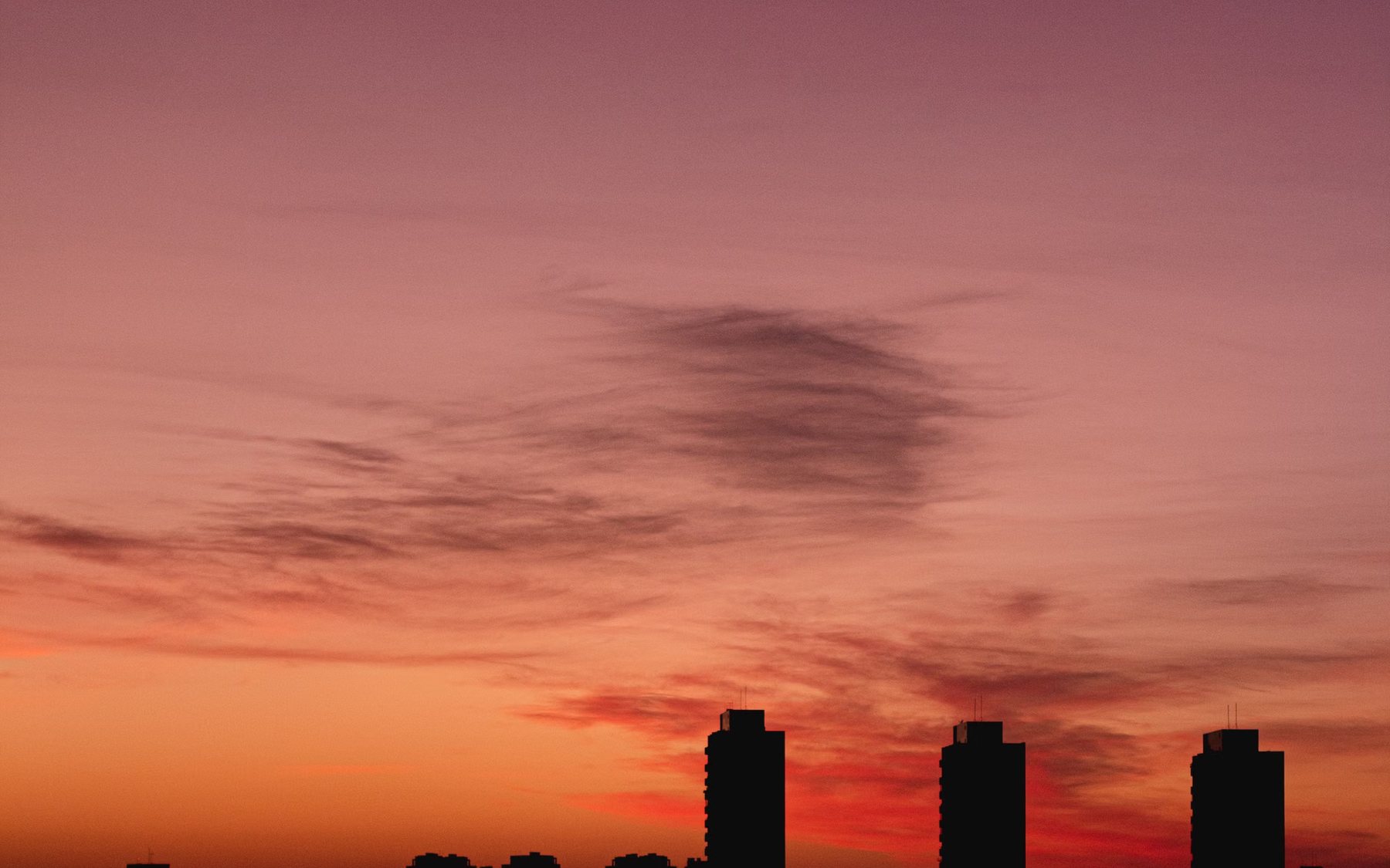 Building silhouettes under a burning evening sky