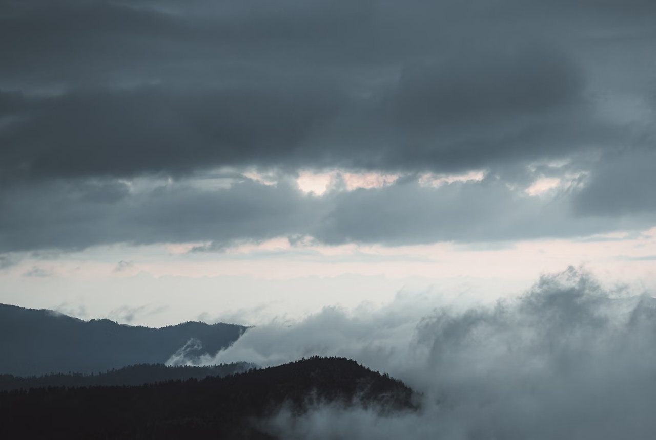 Fog rolling over a mountain ridge at twilight
