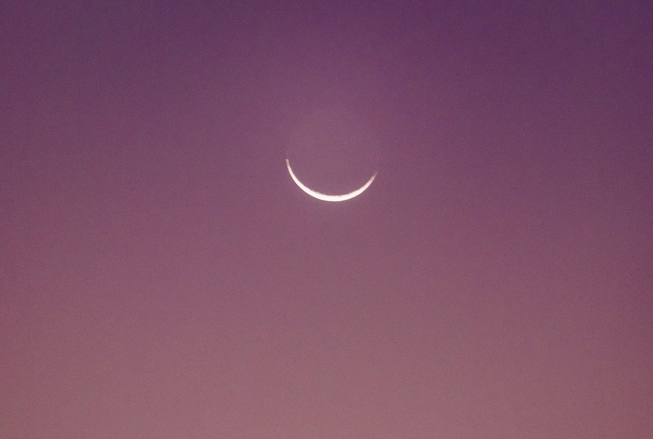 Crescent moon in a mauve evening sky