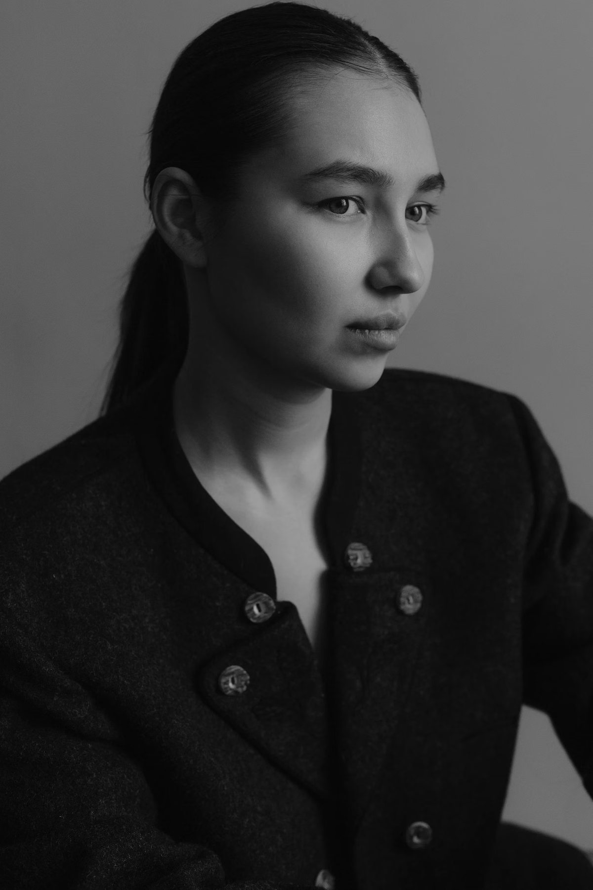 Black and white portrait of a woman in a collarless charcoal wool jacket