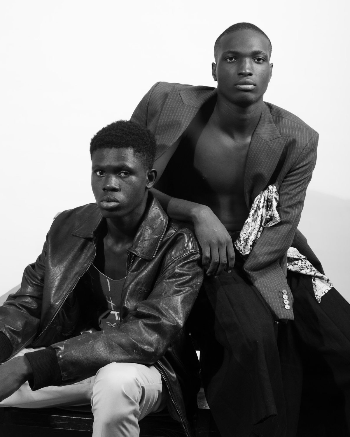 Two models in a leather blouson and an open pinstripe jacket, black and white