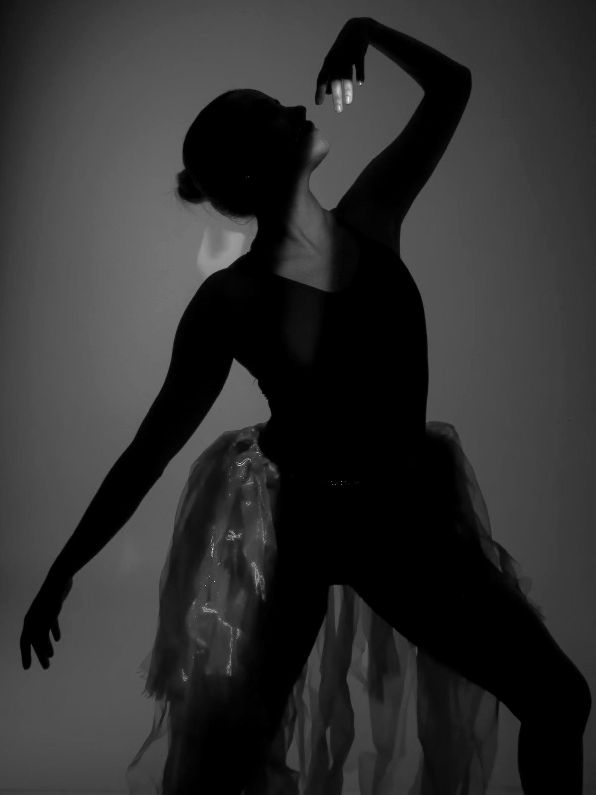 Backlit figure with one arm overhead