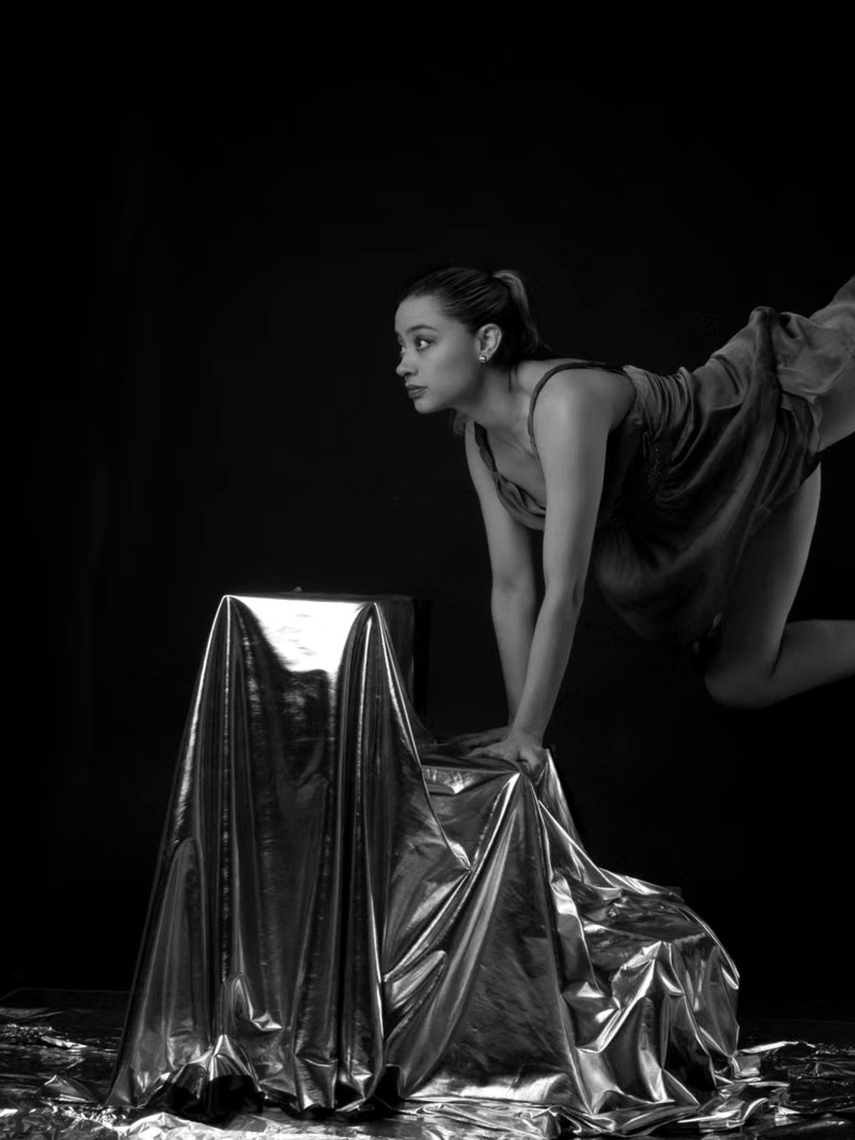 Dancer at rest on a draped plinth