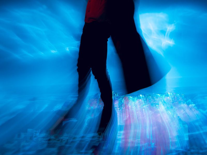 Dancers blurred through blue light