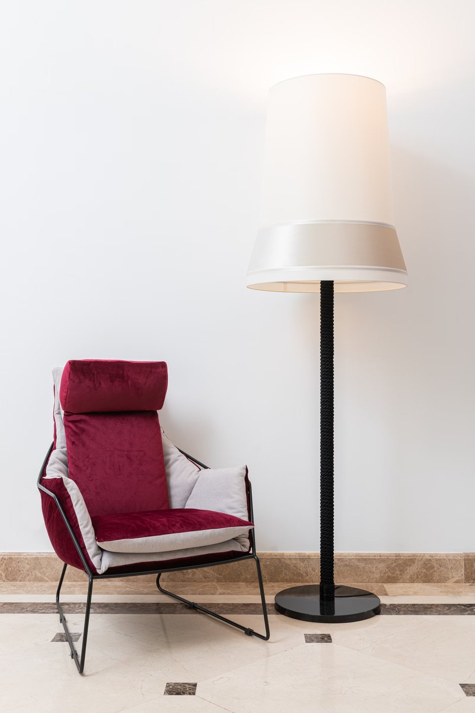 Aker floor lamp beside an upholstered reading chair