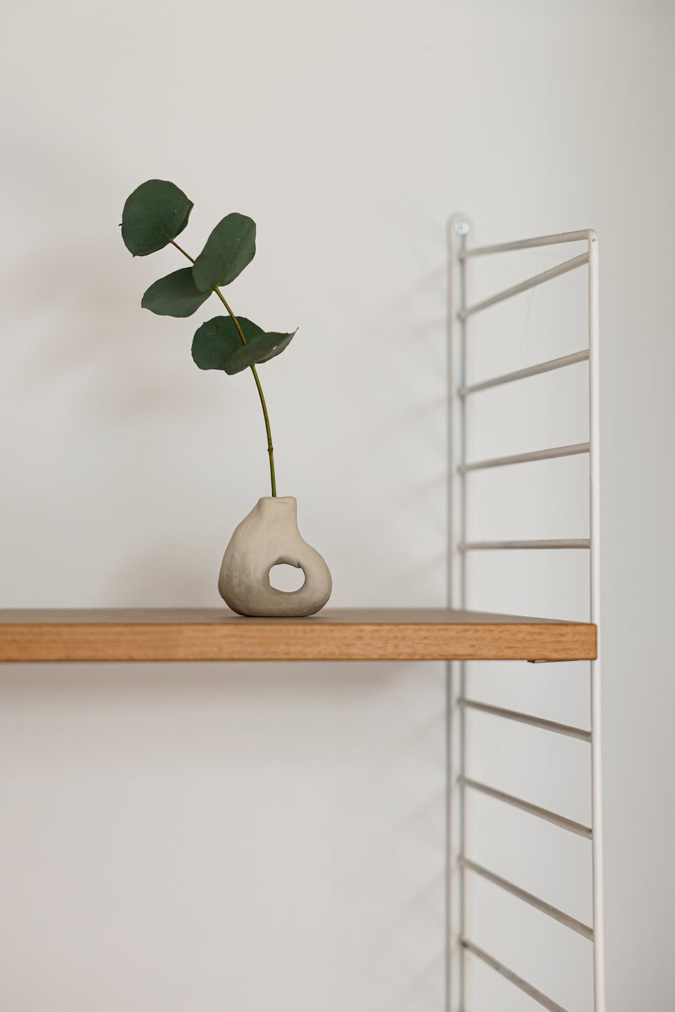Fold wall shelf in oak with a stoneware vase
