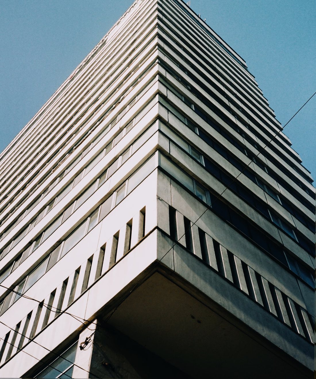 Still from Vertical city — a concrete tower against clear sky