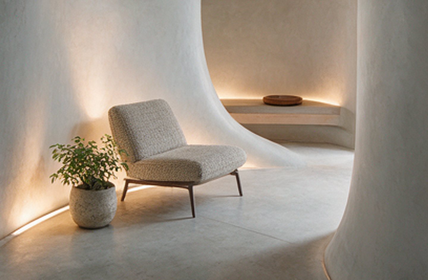 Plastered living room with a boucle lounge chair and cove lighting
