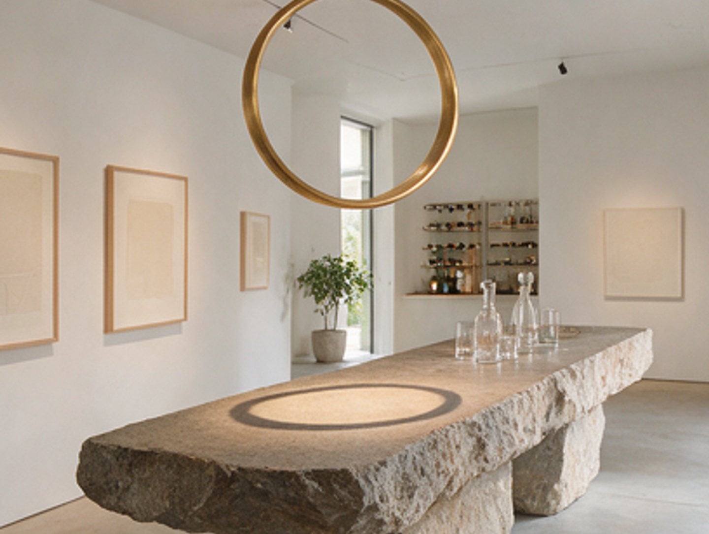 Curved plaster room with a round mirror and framed drawing