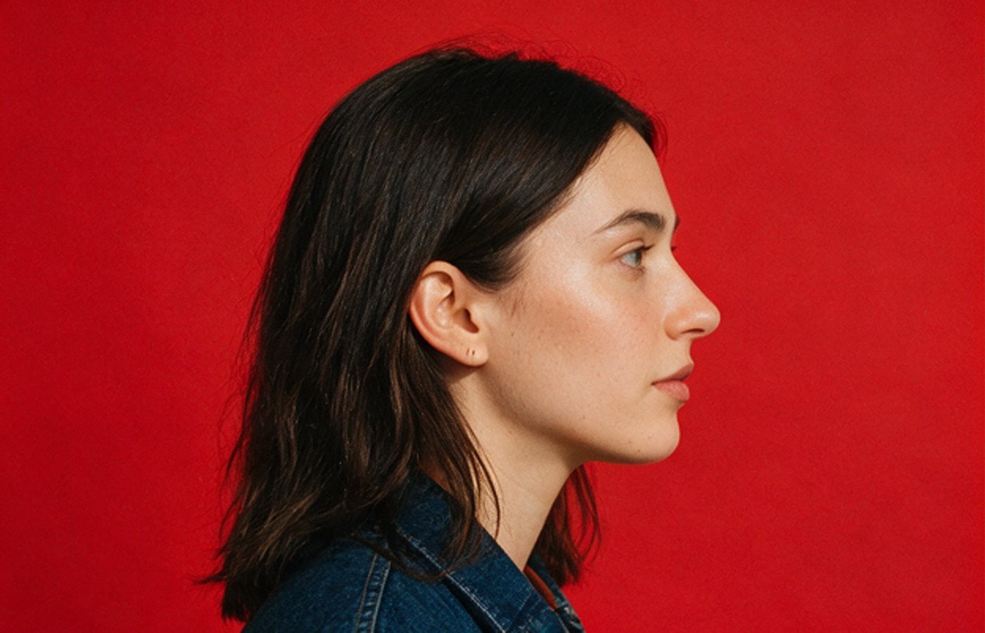 Profile portrait against a red backdrop