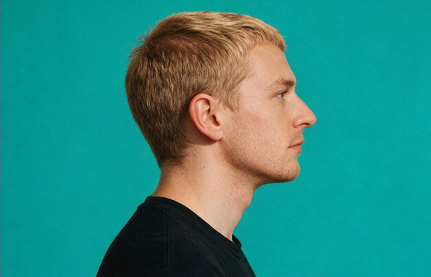 Profile portrait against a teal backdrop