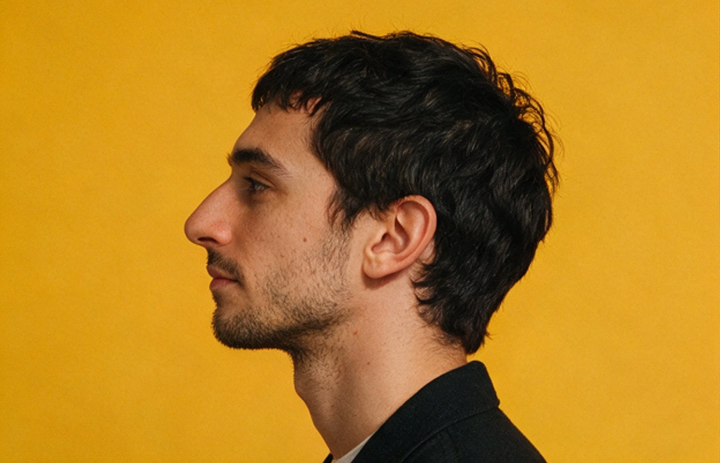 Profile portrait against an ochre backdrop