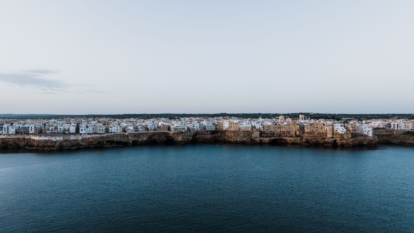 Whitewashed coastal town seen across calm water