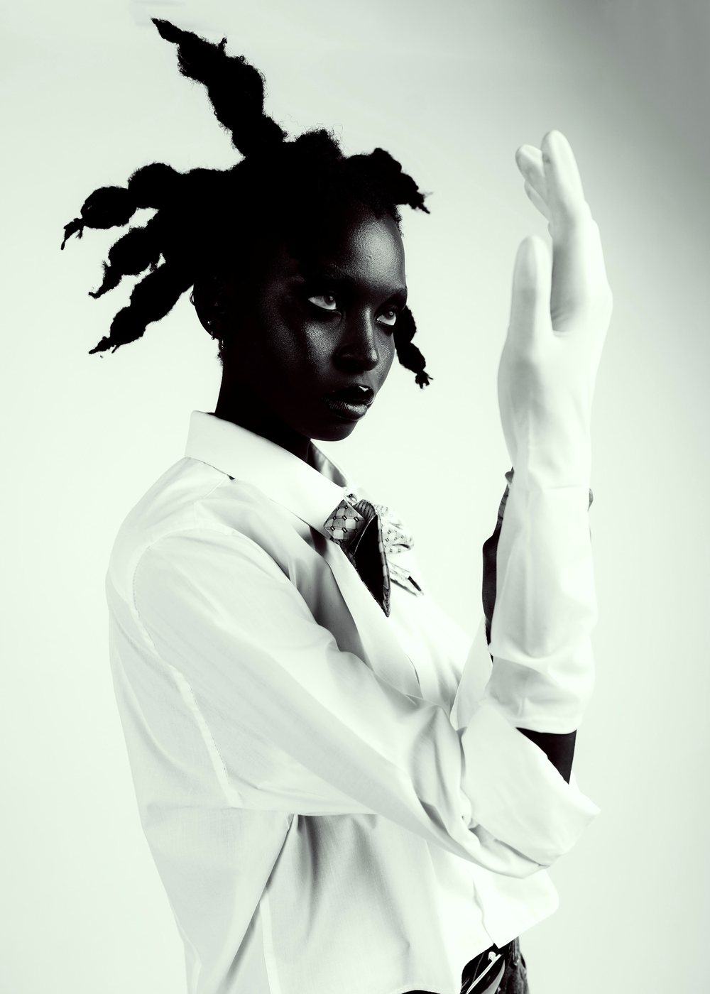 Model with a raised opera glove and white shirt
