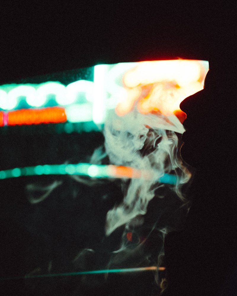 Figure lit by drifting neon