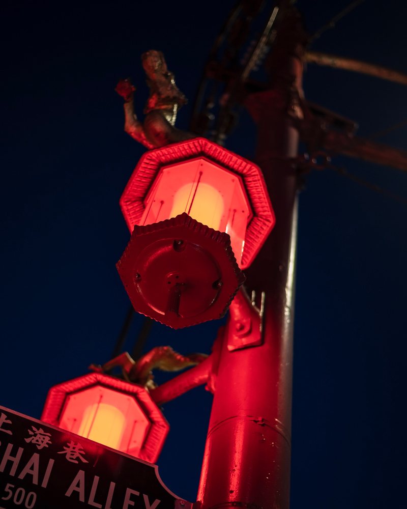 Red neon lantern sign in an alley