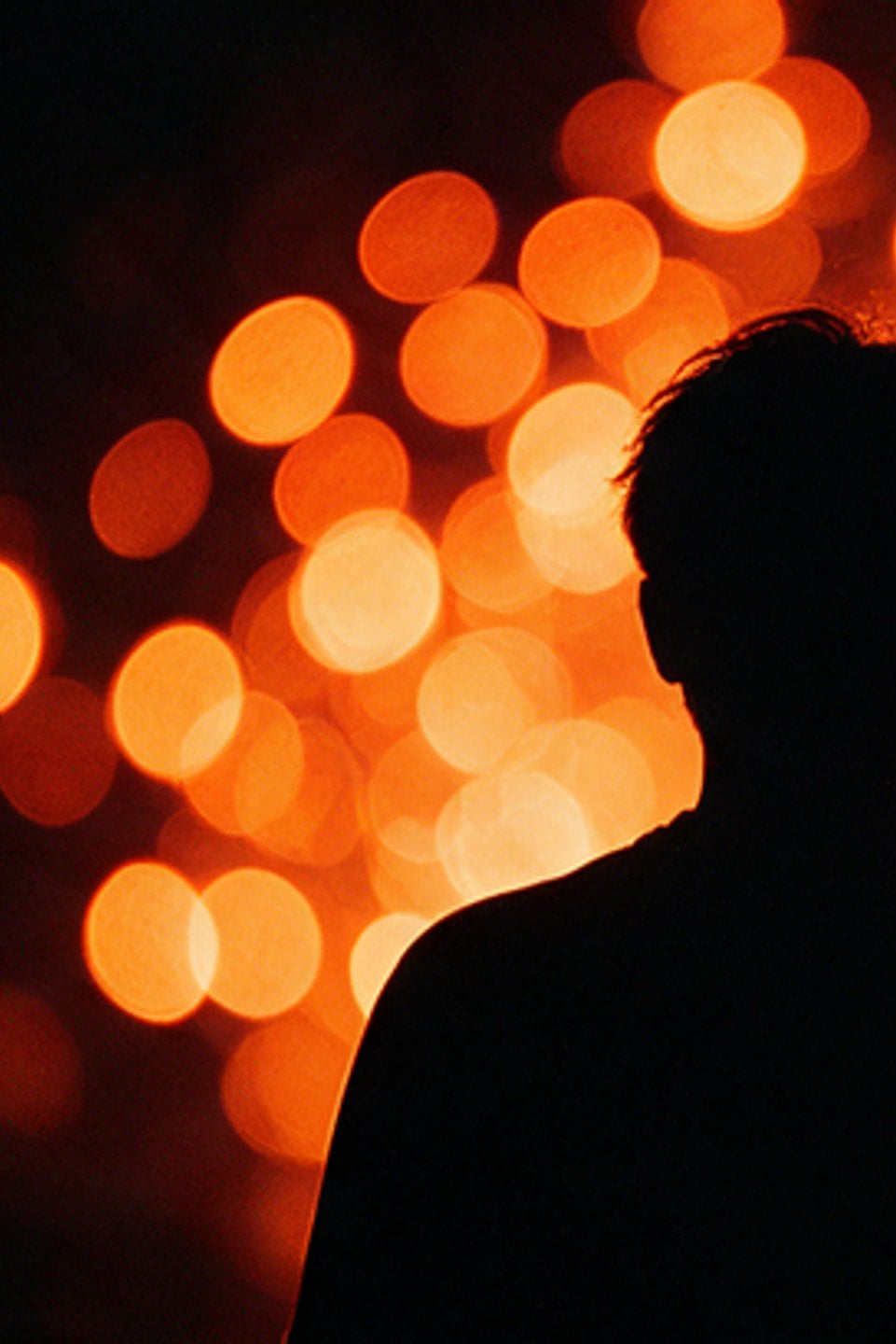 Silhouetted head against warm out-of-focus stage lights